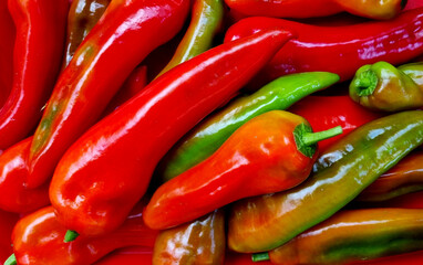 Red and green chilly peppers as a background. Нot pepper pods. Top view close-up, selective focus.
