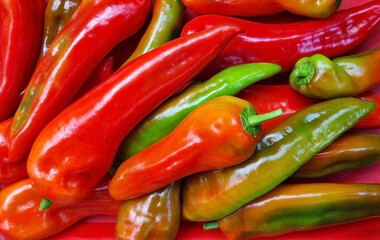 Red and green chilly peppers as a background. Нot pepper pods. Top view close-up, selective focus.