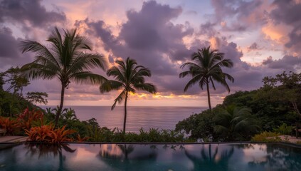 Fototapeta premium Palm trees by the sea with a beautiful tropical sunset over the ocean