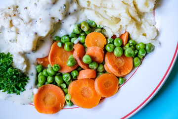 Cod Fillet Fish With Mashed Potatoes Carrots And Peas In A Pasley Sauce