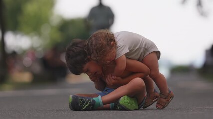Baby climbs onto older brother’s back, playfully hugging him while he bends forward, showing tenderness, family bonding, and joyful emotional connection - Powered by Adobe