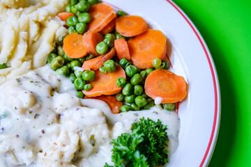 Cod Fillet Fish With Mashed Potatoes Carrots And Peas In A Pasley Sauce