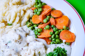 Cod Fillet Fish With Mashed Potatoes Carrots And Peas In A Pasley Sauce