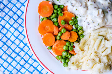 Cod Fillet Fish With Mashed Potatoes Carrots And Peas In A Pasley Sauce