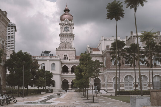 Historic clock tower of Sultan Abdul Samad Building in Kuala Lumpur, Malaysia, with dramatic cloudy sky and colonial architectural charm.