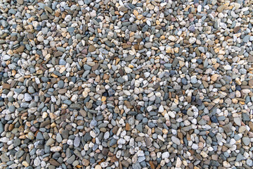 Multicolored Smooth River Pebbles Background. A full frame view of a large collection of small, smooth river pebbles in various colors.