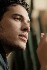 Young Man Looking Out A Window Deep In Thought