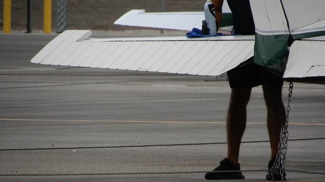 Man Cleans the Wing of an Aircraft on a Sunny Day