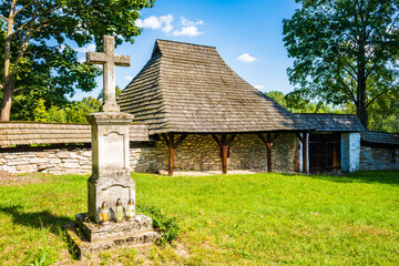 Stone cross in courtyard of famous old orthodox wooden church in Radruz village, Subcarpathia region, Poland