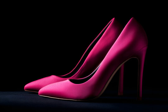 pink high heels on black background