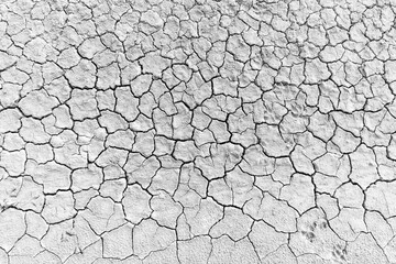 Close-up of dry, cracked soil surface,Close-up image showcasing the intricate patterns of a dry, cracked sand surface, highlighting the natural abstract formations and textures.