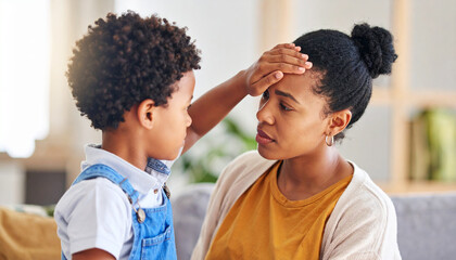 母親のおでこに手を当てて熱を測る子供