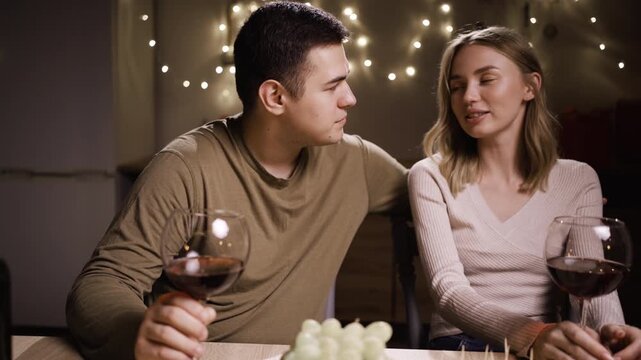 Young lovely couple toasting wine celebrating birthday or date at home. boyfriend and girlfriend holding wineglasses to celebrate Valentines Day