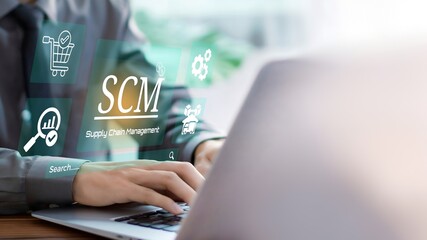 SCM, Supply Chain Management and Logistics System Concept. A business person using laptop with icons representing supply chain management, logistics, production processes on visual screen.
