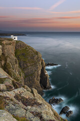 Elin's Tower auf der Insel Holyhead vor der Insel Anglesey bei Sonnenuntergang mit der Küste von Wales im Hintergrund