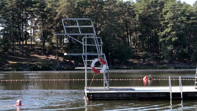 Stockholm, Sweden A man jumps off a diving board into Lake Malaren in summer. 