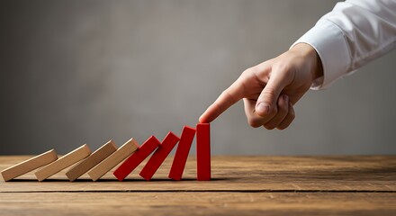 Business professional preventing domino effect of falling blocks