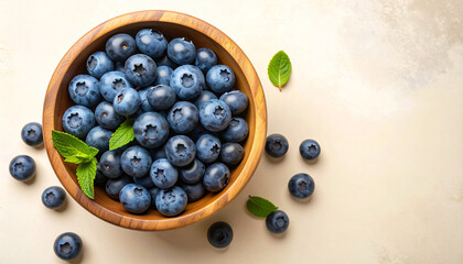 Close-up shot of a wooden bowl filled with fresh, ripe blueberries, with a few scattered around.