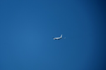 Airplane in the blue sky. A white plane flying in a cloudless blue sky.