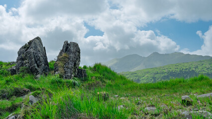 Scenic view of the Gap of Dunloe, Ireland, with rugged rocks, lush green grass, and the majestic...