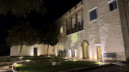 Traditional Masseria Courtyard at Night with Illuminated Trees in Apulia, Italy