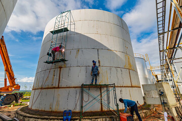 Worker male assembly in progress storage tank oil inspection scaffolding
