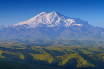 panoramic view of the Bolshoy Bermamyt plateau, with the snow-capped peaks of Mount Elbrus in the background, in early morning, at daytime, Stavropol Krai, Russia