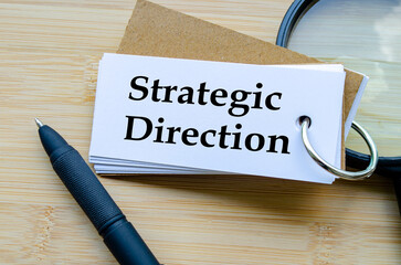 Strategic Direction, Notepad titled Strategic Direction with miniature ladder placed beside it on...