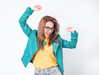 Excited young woman at winner, wearing green leather jacket, isolated on white background. Yes...