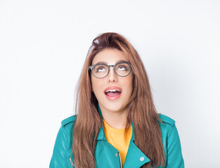 Surprised young woman looking up to free space - copy space for your product or text, wearing green...