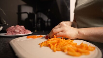Woman chopping carrots on cutting board