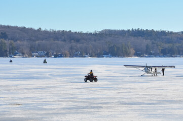 ATV and airplane over frozen lake in winter