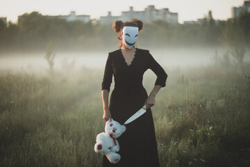 Spooky Halloween scene with mask, teddy bear, and knife