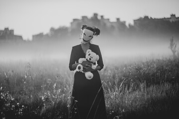 Spooky Halloween scene with mask, teddy bear, and knife