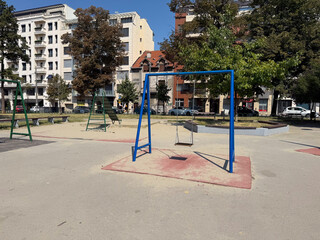 Empty playground with swings and climbing frames. Urban infrastructure and childhood leisure.