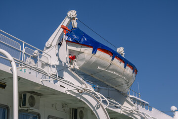 A lifeboat with an engine and steering mechanism on the upper deck of the ship. A ship's lifeboat...