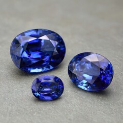 Fototapeta premium Three oval-cut sapphires on a gray surface