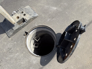 Open manhole on street with ladder. Infrastructure, safety, and city maintenance.