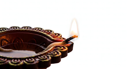 Diwali: A detailed, macro studio shot of a lit earthen oil lamp (diya) with a bright flame. The focus is on the intricate design of the diya and the glowing warmth of the flame. 