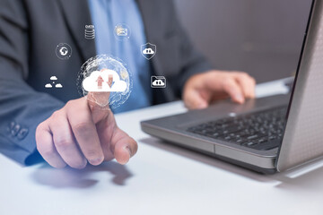 A businessman interacts with digital icons representing cloud computing and data management while using a laptop.