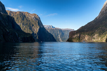 Tourist boat cruising through Milford Sound in South Island, New Zealand