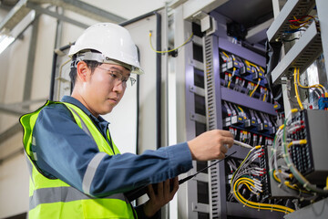 Engineer conducts detailed inspection of substation control panel ensuring proper maintenance and...