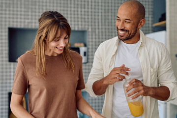 Smiling man and woman preparing breakfast together in a modern kitchen, enjoying a healthy lifestyle
