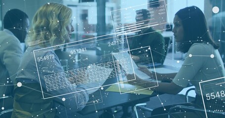 Collaborating women analyzing documents on laptops at office table with holographic overlays