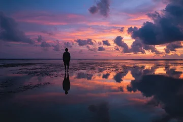 Keuken achterwand Reflectie Silhouette of a person at sunset, reflected in calm water  © Doyok