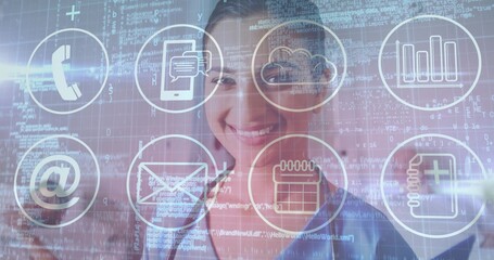Smiling Indian woman in blue shirt displaying telephone, cloud, chat icons with code in office