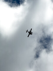 Airplane Silhouette Flying Through Cloudy Sky