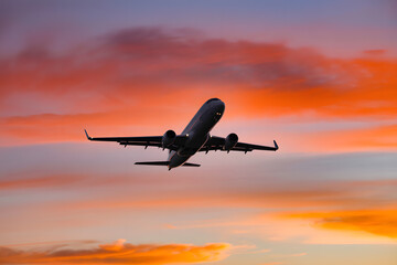 Airplane Flying Against a Vibrant Sunset Sky Captures the Beauty and Awe of Flight and Ethereal Glow