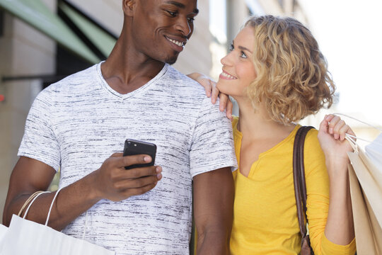 multiethnic couple shopping man holding smartphone
