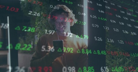 Holding smartphone, adult man checking stock numbers in lounge with wired earphones and LED tubes